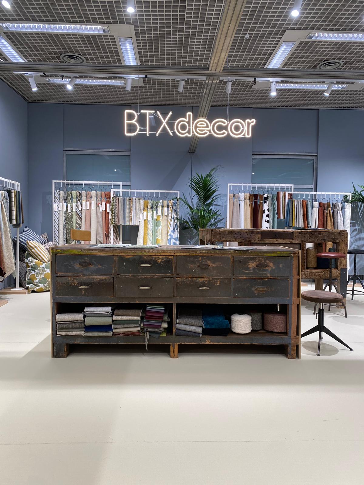 Stand BTXdecor con campionari di tessuti e mobile espositivo in legno a Villa Erba.