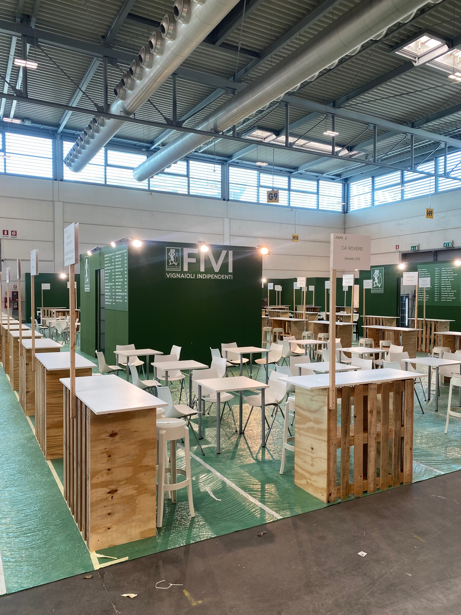 Area FIVI a Vinitaly prima dell'apertura, con postazioni di degustazione e moquette ancora protetta.