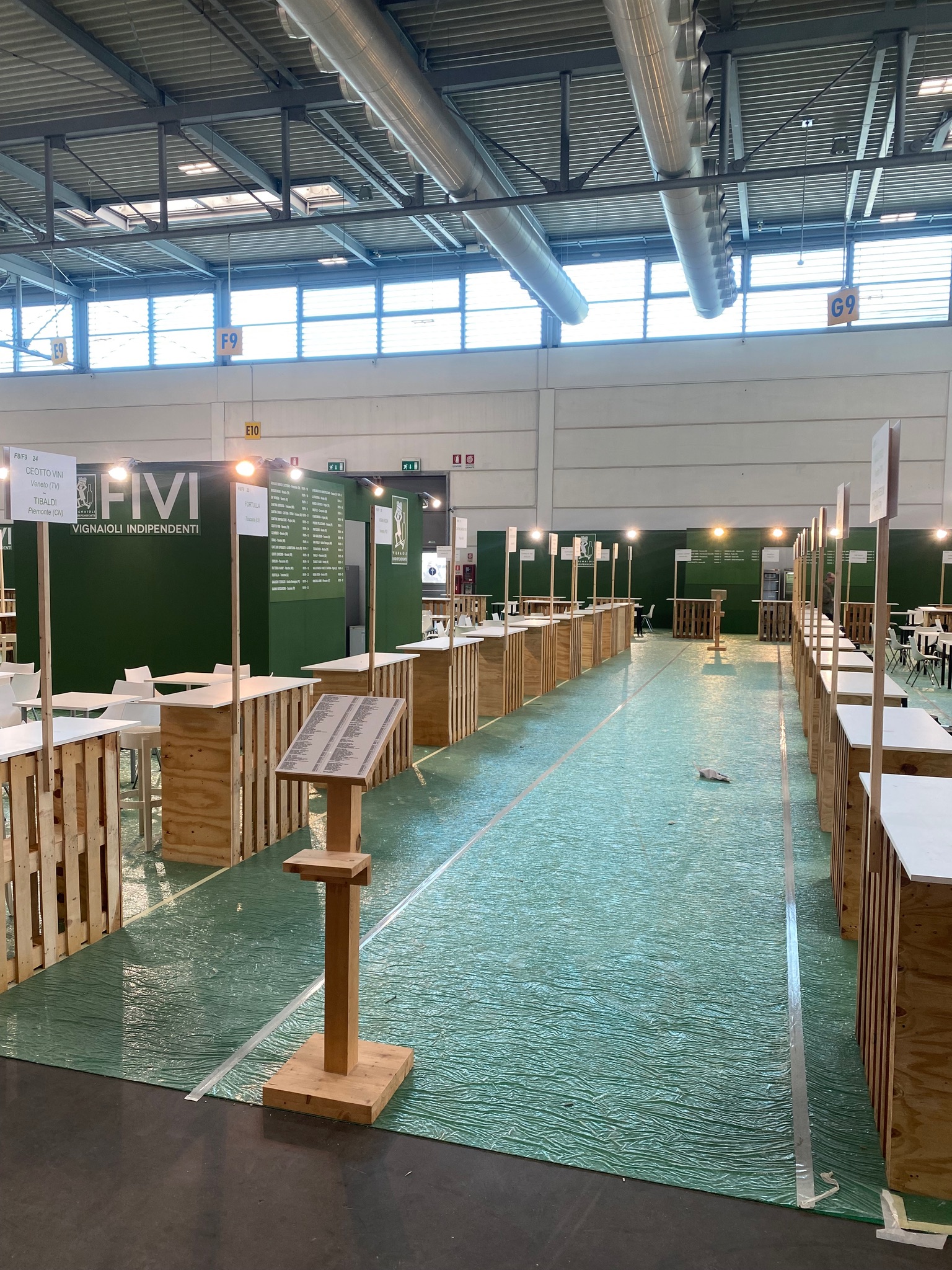 Spazio collettivo FIVI a Vinitaly durante l'allestimento: corridoio centrale e postazioni dei vignaioli.