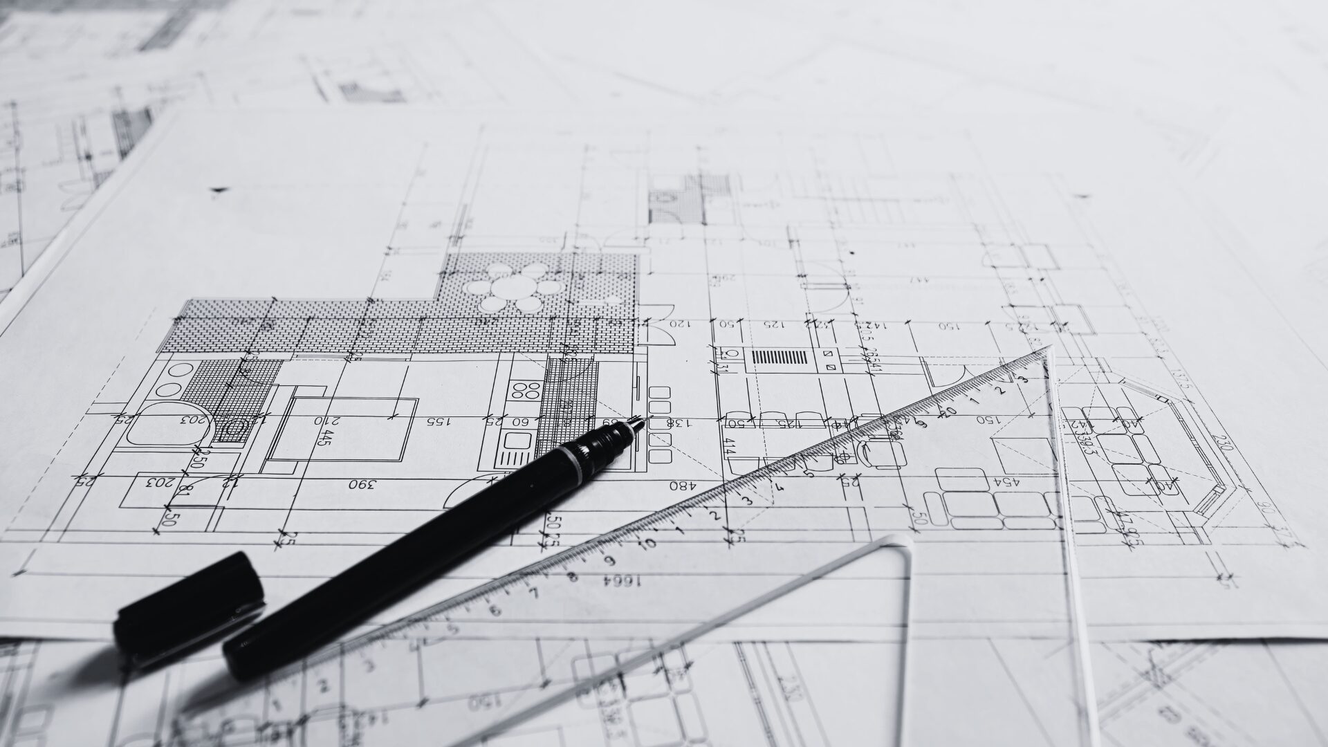 Disegni tecnici con quote, righello e penna sul tavolo di progettazione.
